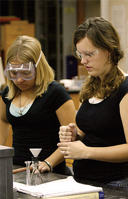 Chemistry students observing experiment.