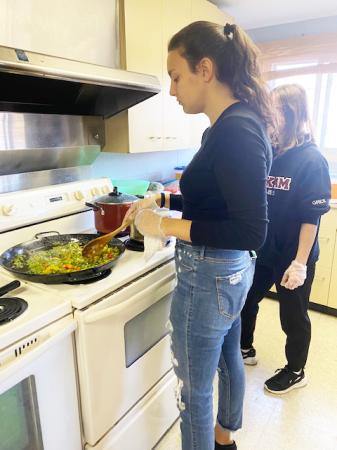 Carla Flores, a WIU student from Spain, prepares paella for the evening's meal.