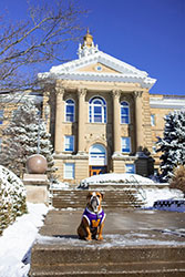 Ray sitting in front of a snowy Sherman Hall