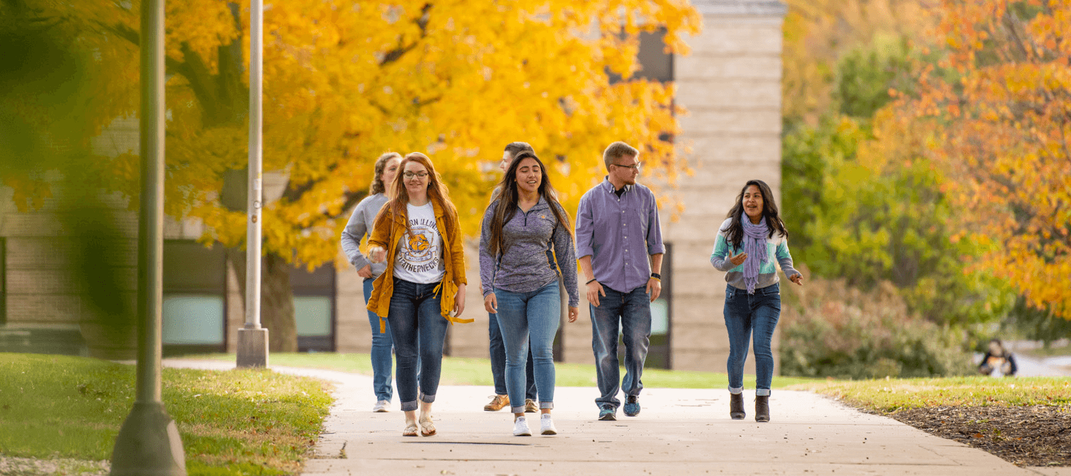 A group of students walking down a sidewalk.