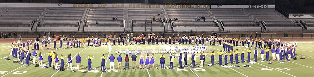 Band in circle on field playing Never Walk Alone