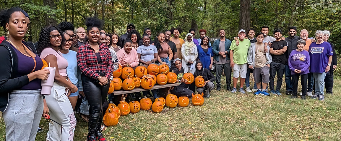 group photo of all the students (around 30) who participated, a few faculty members, and the students' carved pumpkins